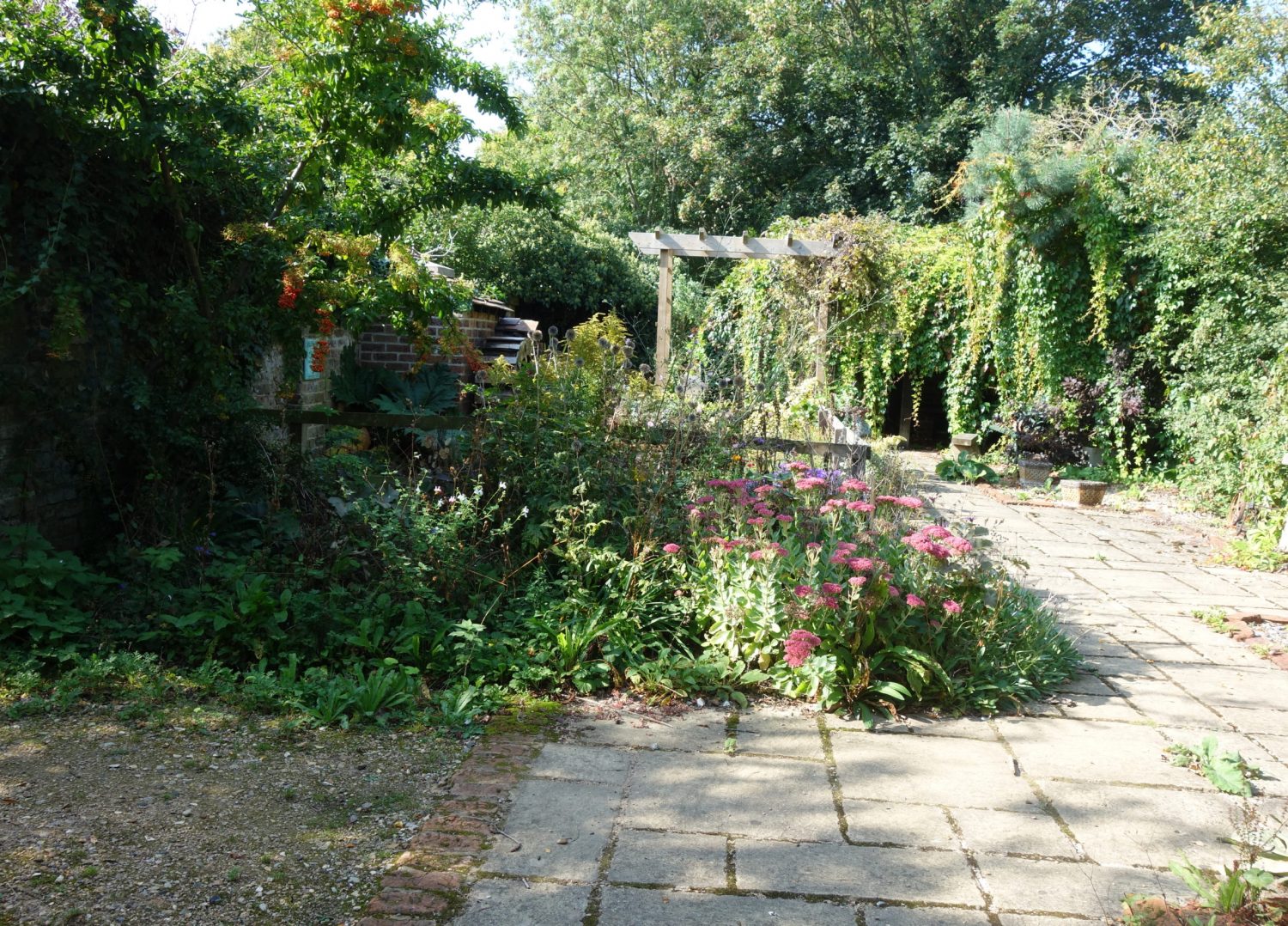 Instead of raised flower beds we now have a pond with a water wheel fountain and a covered area with a collection of antique agriculture tools.